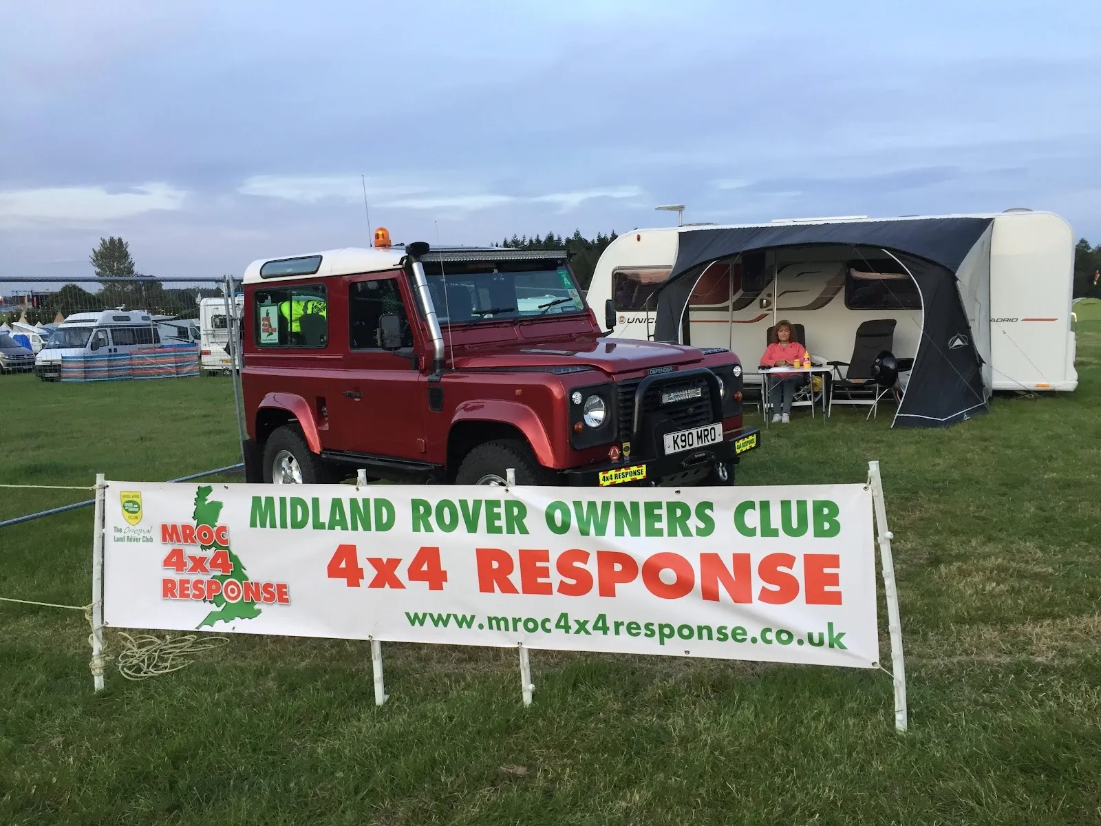 The MROC 4x4 Response banner in front of a Land Rover at a festival campsite