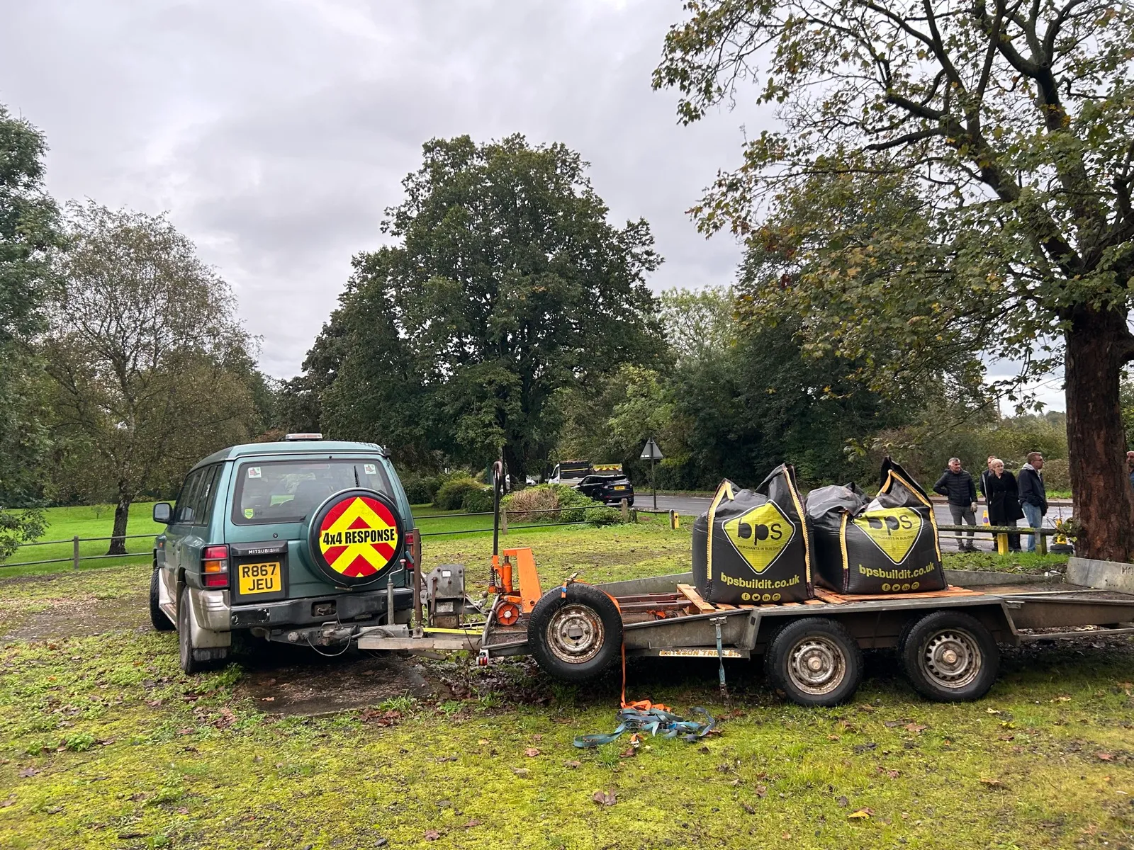 A 4x4 Response vehicle towing a plant trailer loaded with bulk bags across parkland